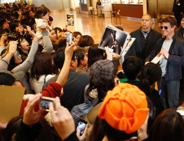 Tom Cruise (dir.) atende fãs ao desembarcar no aeroporto de Haneda, em Tóquio / Crédito: Issei Kato/Reuters