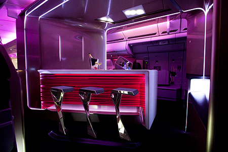 Passageiros da primeira classe podem tomar uma taça de vinho no bar do avião. Crédito: Reprodução/Virgin 