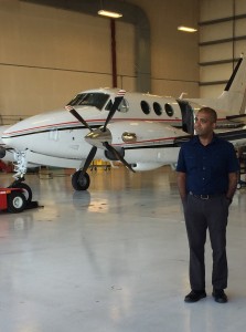 O pesquisador Santosh Mathan perto do King Air usado nos testes (Divulgação/Honeywell)