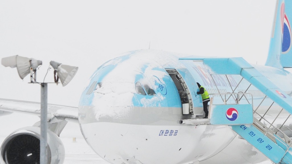 O acúmulo de neve altera o desenho aerodinâmico do avião e coloca o voo em risco (Foto: Lee Seok-hyung/Reuters)